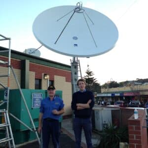 Ian Kirk and Tristan Tobin standing in front of a satellite dish