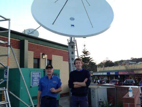 Ian Kirk and Tristan Tobin standing in front of a satellite dish