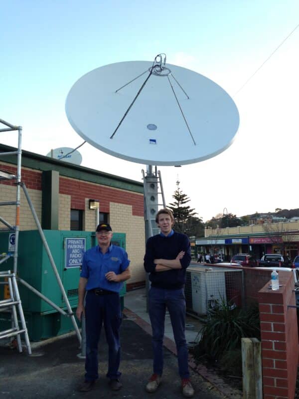 Ian Kirk and Tristan Tobin standing in front of a satellite dish